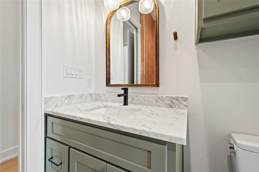 Half bathroom with vanity and toilet