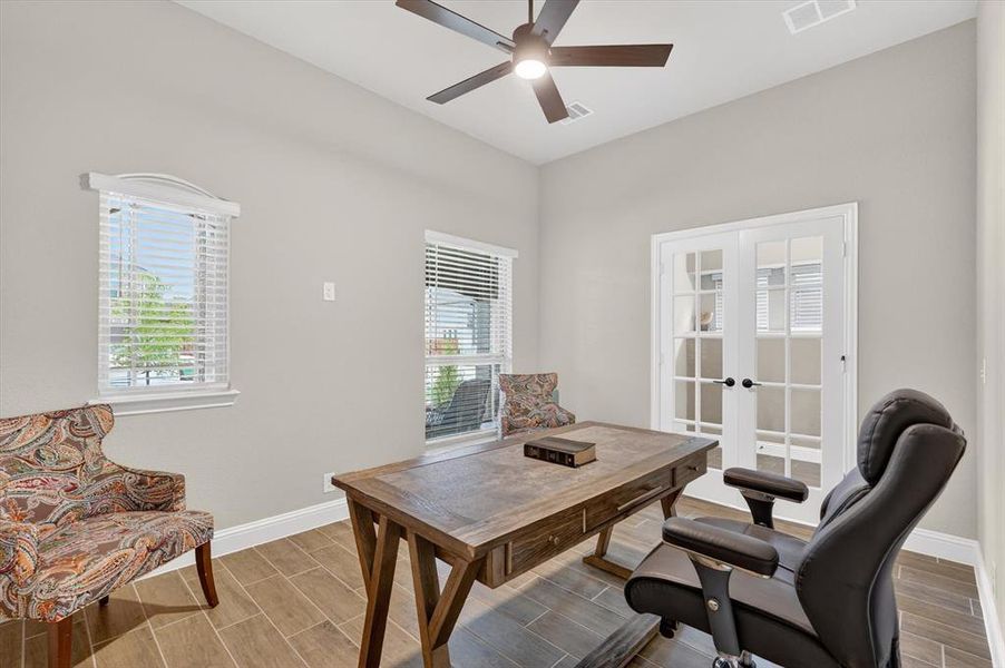 Room featuring neutral wall tones, wood-finish tile flooring, and a ceiling fan with integrated lighting Room featuring neutral wall tones, wood-finish tile flooring, and a ceiling fan with integrated lighting
