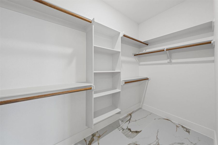 Gleaming marble-look tile floors anchor this spacious storage area with integrated custom shelving.