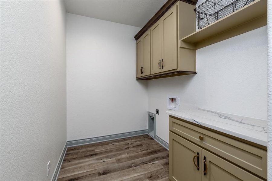 Spacious laundry room with build in cabinetry and counter space.