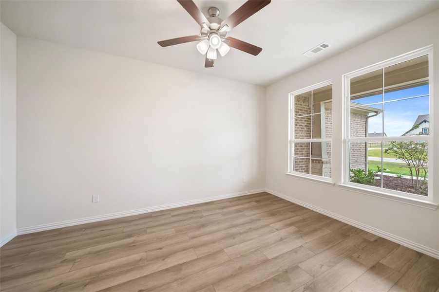 Empty room featuring wood finished floors and a ceiling fan