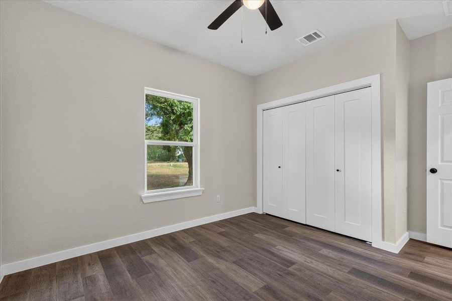 Rich wood-look flooring and a wide closet define this versatile secondary bedroom. Rich wood-look flooring and a wide closet define this versatile secondary bedroom.