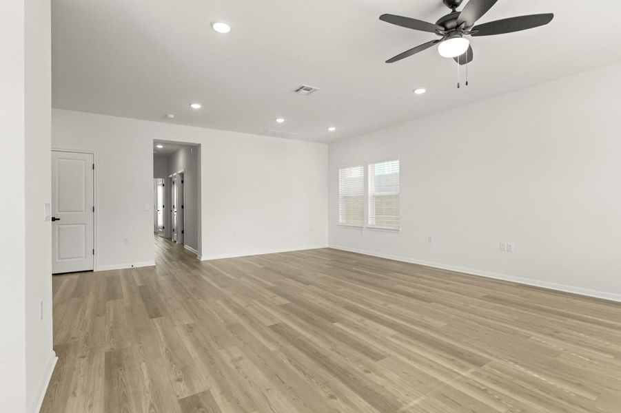 Empty room featuring a ceiling fan, light wood-type flooring, and recessed lighting