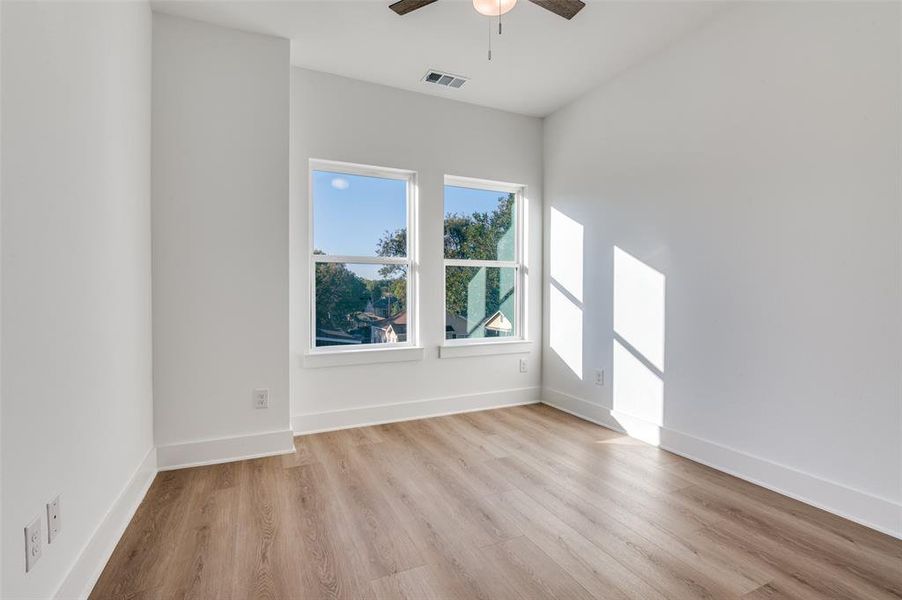 Spare room featuring light wood finished floors and a ceiling fan