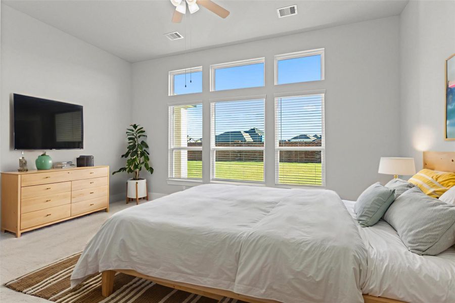 Virtually staged — Another styled view of the primary bedroom highlights the possibilities of this serene space. Neutral tones, high ceilings, and abundant light provide a calm, elegant backdrop ready to fit your personal style. *Photo Staged*
