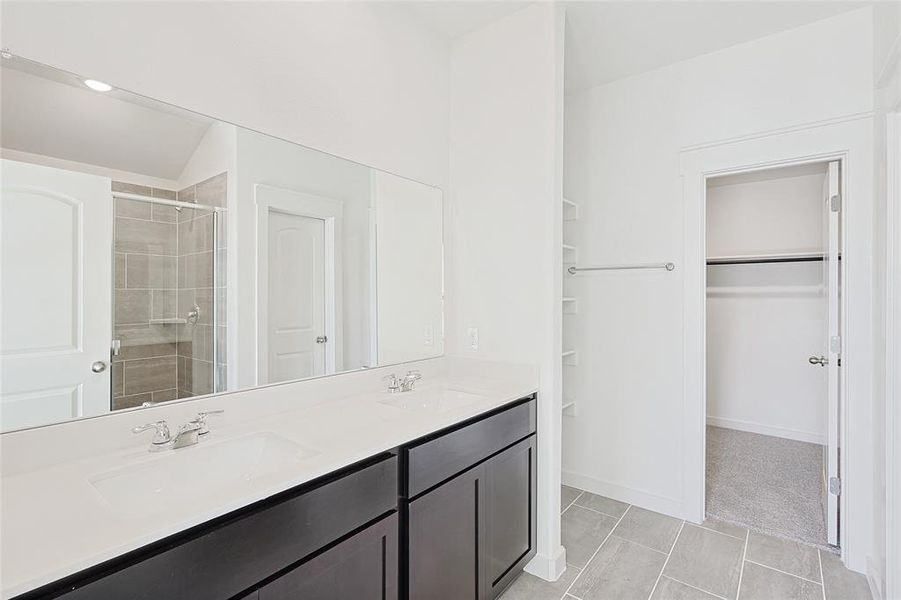 Bathroom with tile patterned flooring, vanity, and a shower with shower door