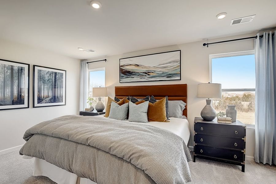 A bedroom with a bed and lamps.