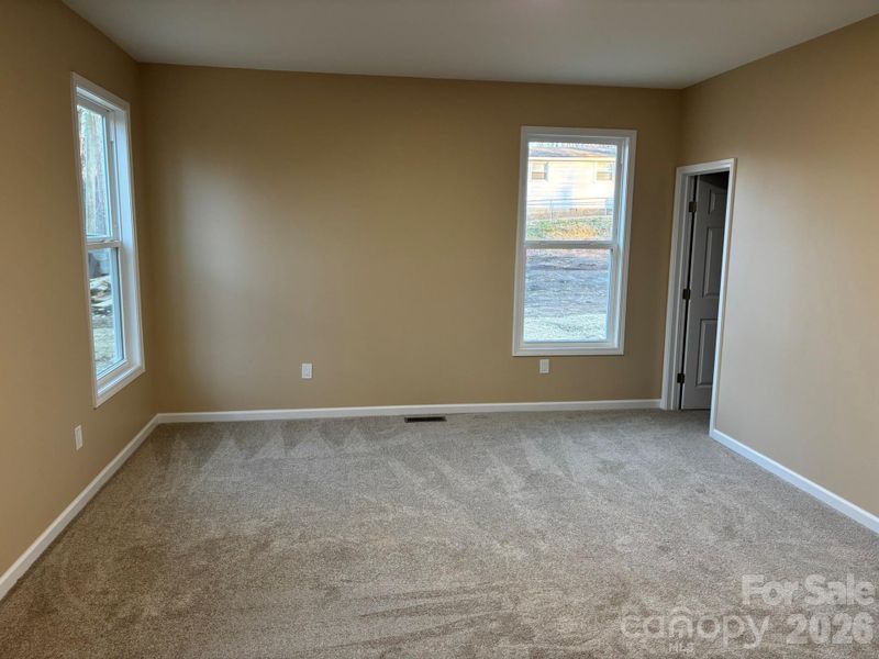 Large primary bedroom with 9 ft ceilings and plenty of natural sunlight.