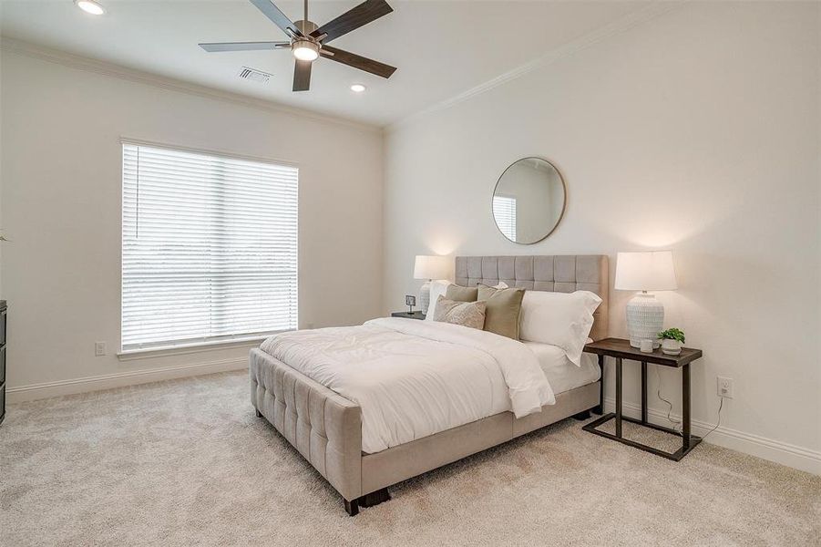 Primary bedroom featuring ceiling fan, crown molding and 10 ft ceilings with 8 ft doors