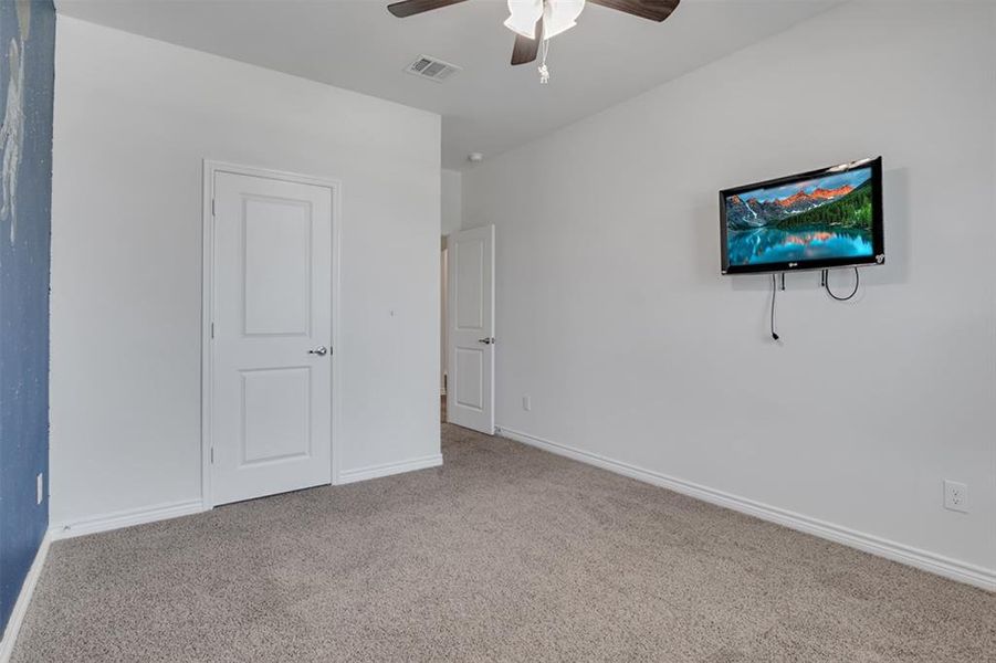 Carpeted spare room featuring ceiling fan