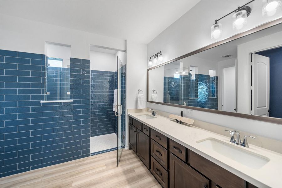 The primary bath has double sinks, alder cabinets, and an over-sized walk-in shower with 2 shower heads.