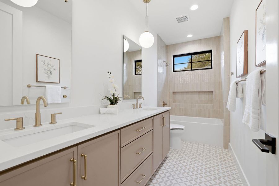 Bathroom featuring shower / washtub combination, double vanity, and recessed lighting