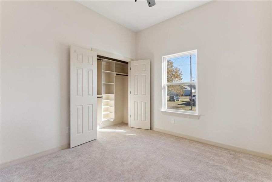 Unfurnished bedroom with light carpet, a closet, and ceiling fan