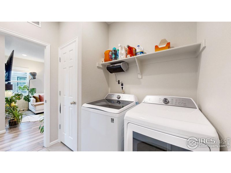 Laundry space with coat/broom closet.