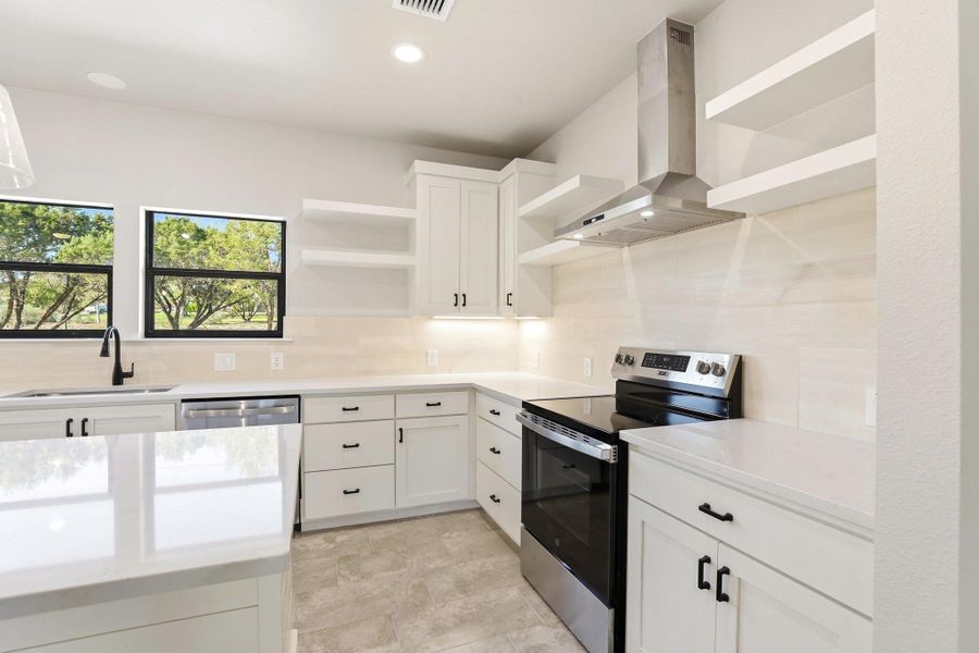Bright, open-concept kitchen with crisp white cabinetry and a full suite of stainless steel appliances. Bright, open-concept kitchen with crisp white cabinetry and a full suite of stainless steel appliances.