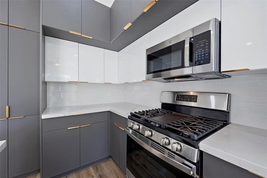 The home is equipped with stainless steel appliances, including a gas range. The dual toned cabinets add a custom touch to this kitchen.