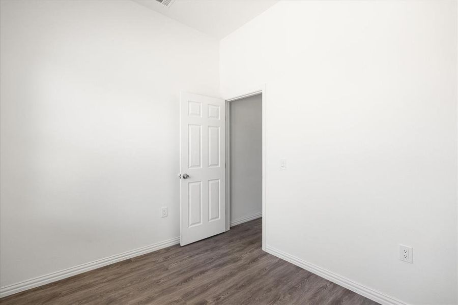 Empty room featuring dark wood-type flooring