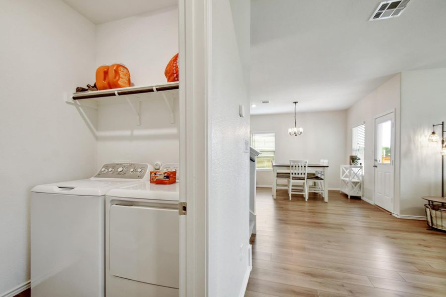 Laundry room featuring independent washer and dryer, plenty of natural light, light wood-style floors, visible vents, and laundry area