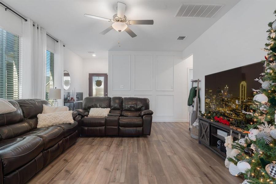 Living room featuring ceiling fan, hardwood / wood-style floors, and a healthy amount of sunlight