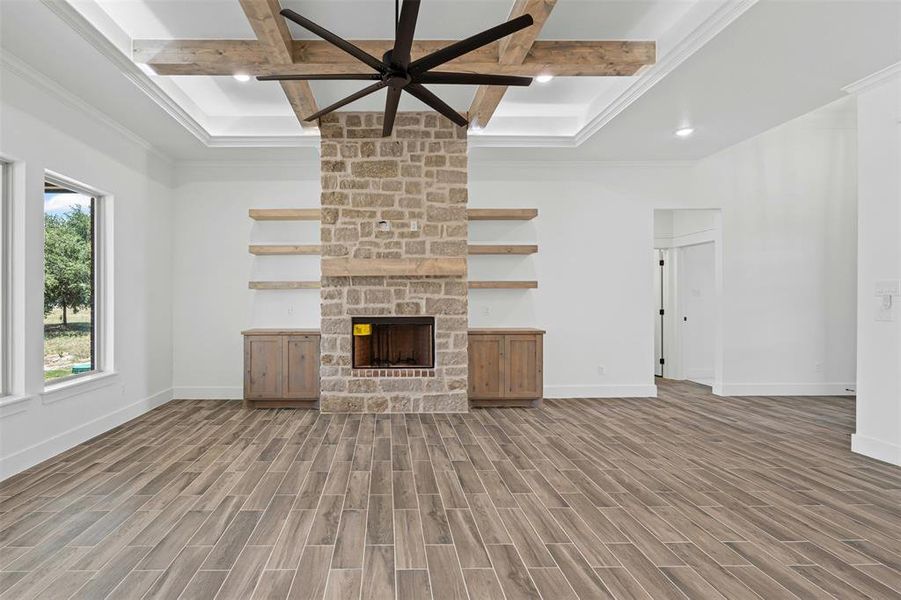 Unfurnished living room with coffered ceiling, beamed ceiling, light wood-style flooring, a fireplace, and recessed lighting Unfurnished living room with coffered ceiling, beamed ceiling, light wood-style flooring, a fireplace, and recessed lighting
