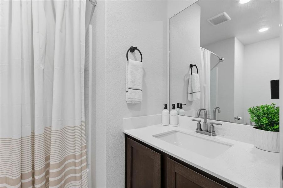 Full bath with vanity and a shower with curtain