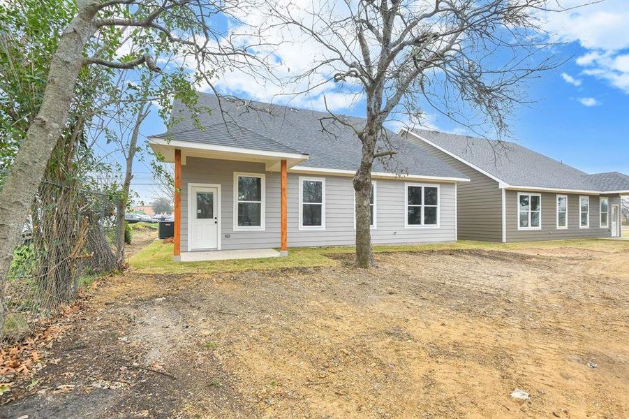 Rear view of house featuring a patio area and roof with shingles