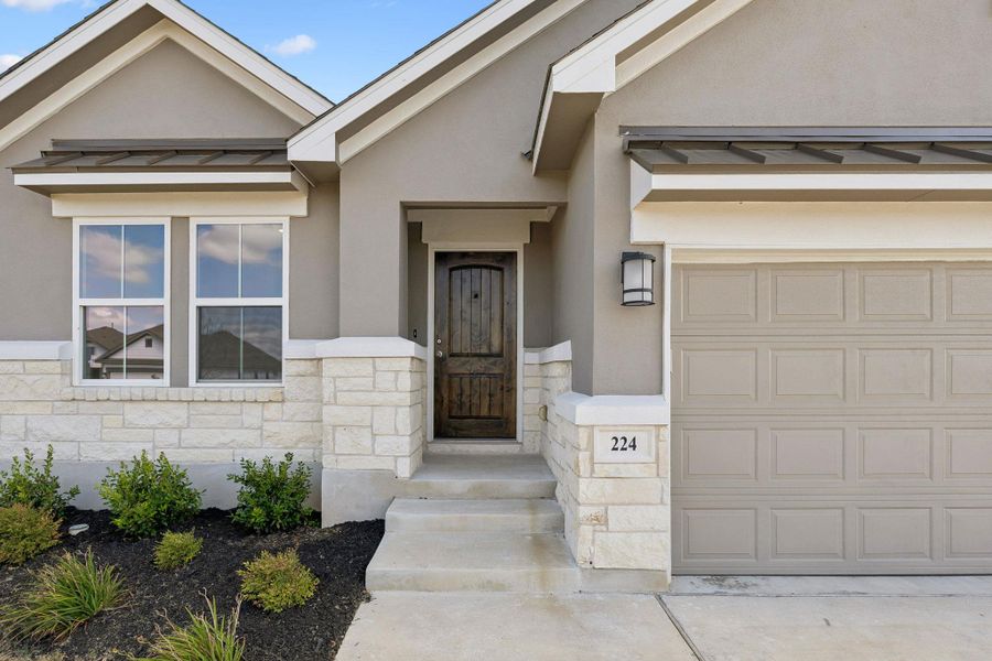 An inviting stone and stucco exterior anchors this modern home with classic architectural appeal.