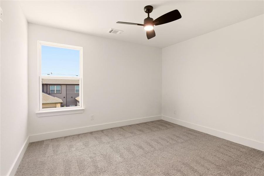 Empty room with light colored carpet and ceiling fan