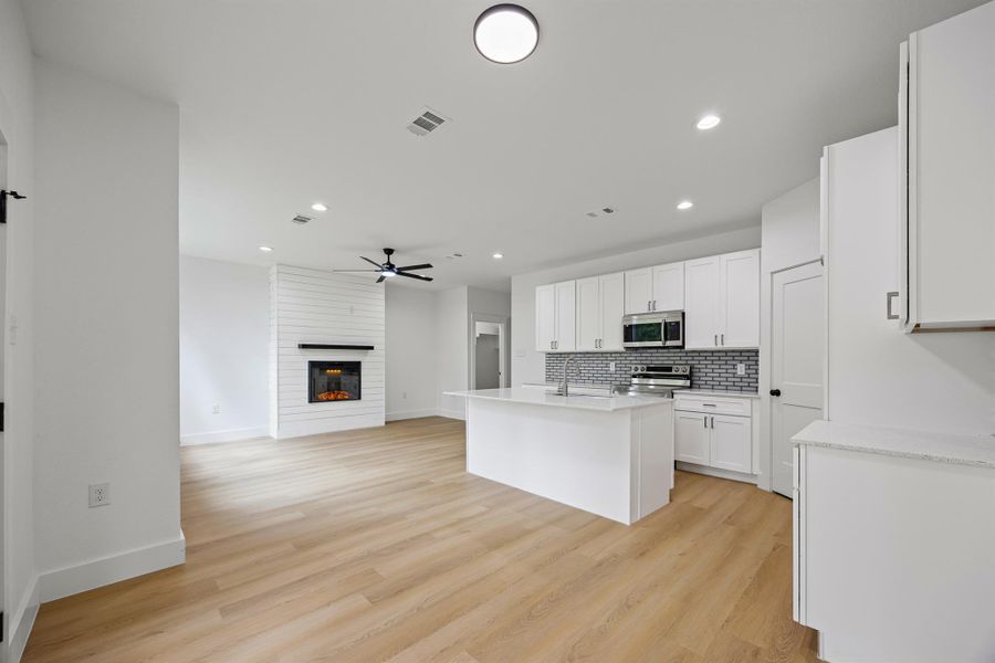 Kitchen featuring appliances with stainless steel finishes, backsplash, a ceiling fan, open floor plan, and recessed lighting Kitchen featuring appliances with stainless steel finishes, backsplash, a ceiling fan, open floor plan, and recessed lighting