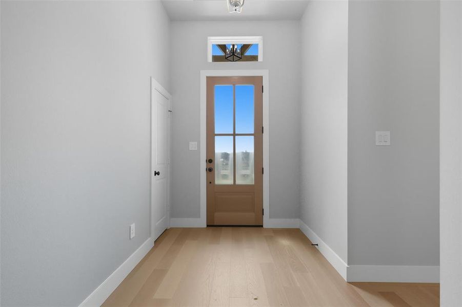 Doorway with plenty of natural light and wood finished floors Doorway with plenty of natural light and wood finished floors