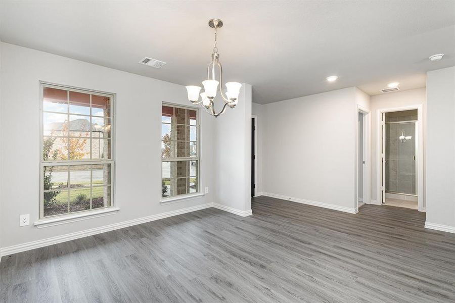 Unfurnished dining area with dark hardwood / wood-style flooring and a notable chandelier