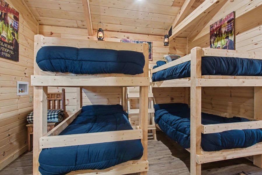 Bedroom featuring wood walls, wood finished floors, lofted ceiling, and wood ceiling