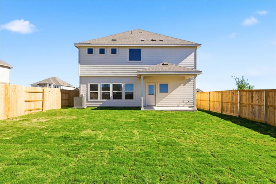 Rear view of house with a shingled roof, a fenced backyard, and a patio
