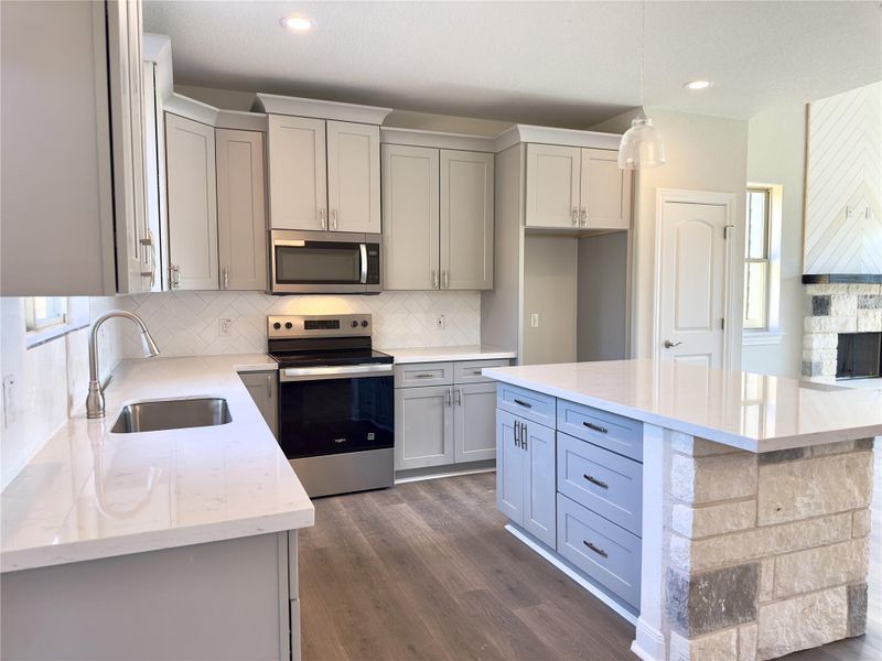 Kitchen featuring appliances with stainless steel finishes, gray cabinets, backsplash, light stone countertops, and recessed lighting Kitchen featuring appliances with stainless steel finishes, gray cabinets, backsplash, light stone countertops, and recessed lighting