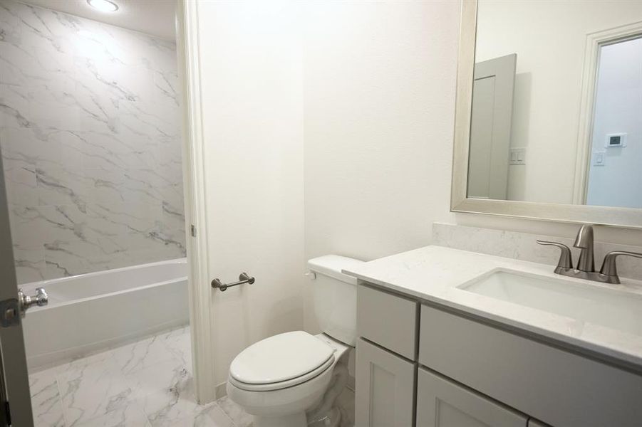 Full bathroom featuring tile patterned floors, vanity, toilet, and tiled shower / bath