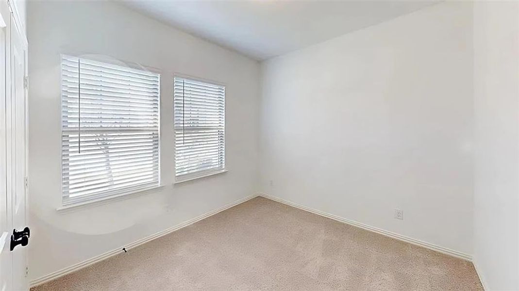 Carpeted spare room with baseboards