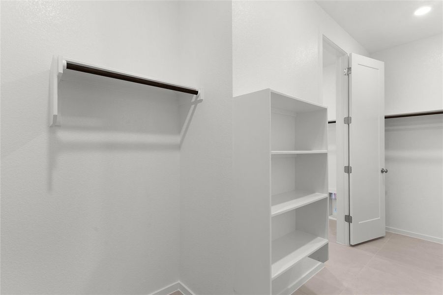 Walk in closet with light tile patterned floors