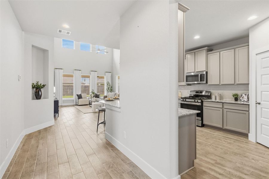 Your thoughtfully designed hallway leads seamlessly into the heart of the home, creating an airy connection between the living spaces and kitchen.
