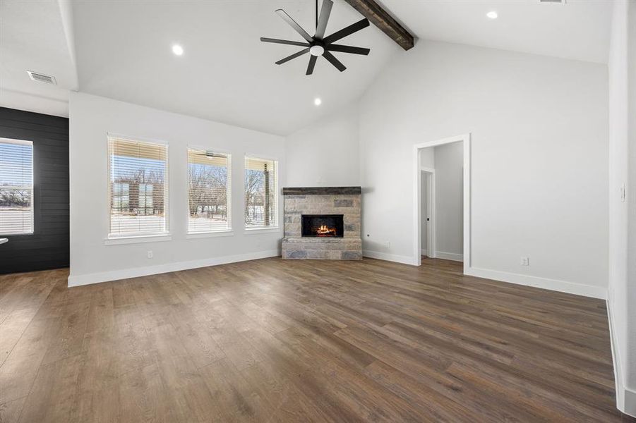 Unfurnished living room with a stone fireplace, dark wood-style floors, ceiling fan, and recessed lighting