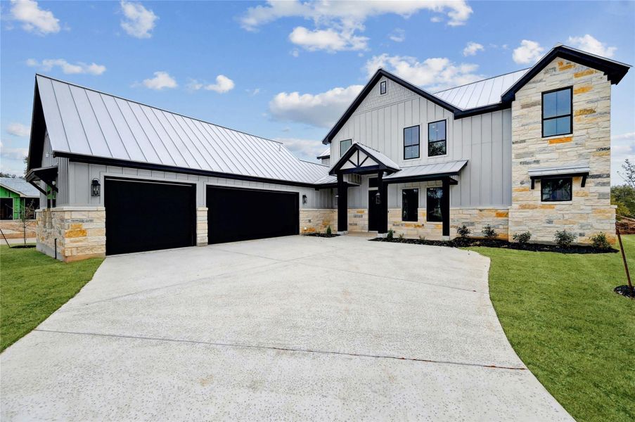 Modern farmhouse with metal roof, a standing seam roof, an attached garage, and board and batten siding