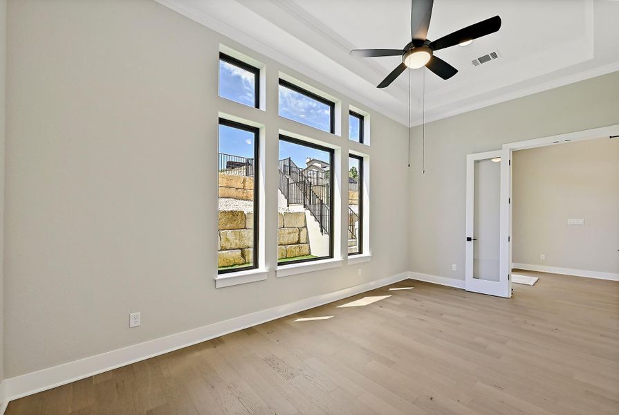 An airy interior features elegant hardwood flooring and a stylish ceiling fan with ample natural light.
