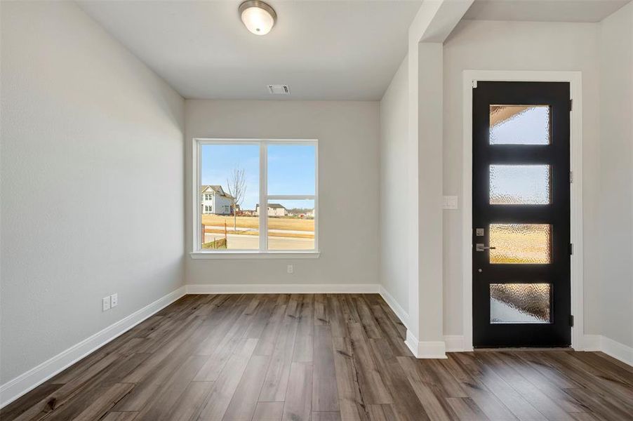Foyer entrance with dark wood-type flooring and baseboards