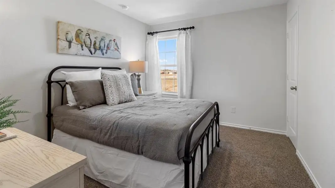 Bedroom featuring neutral wall paint, carpet flooring, a window with curtains, and a white interior door