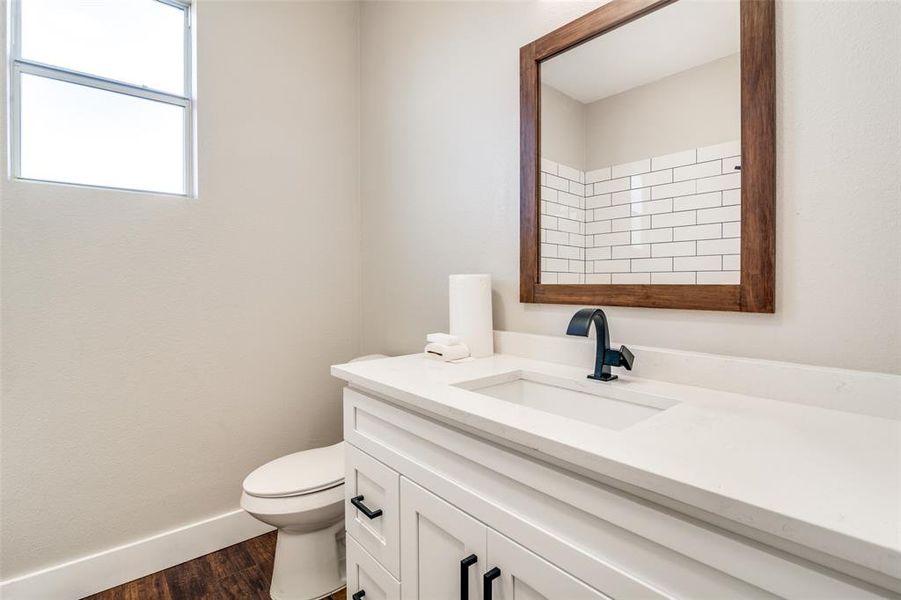 Bathroom with toilet, vanity, and hardwood / wood-style flooring