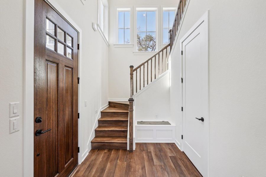 Entryway featuring dark wood-style floors and a high ceiling