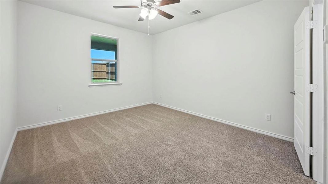 Spare room with carpet and a ceiling fan