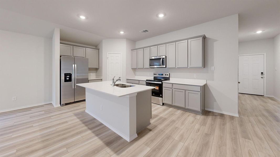 A spacious, open-concept kitchen features a large island and ample counter space for culinary endeavors.