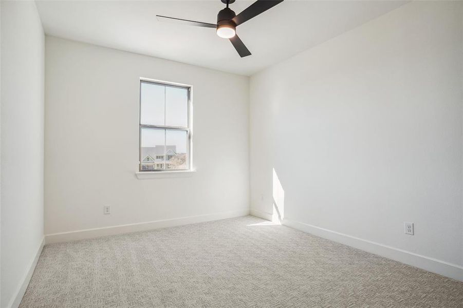 Spare room featuring ceiling fan and light carpet