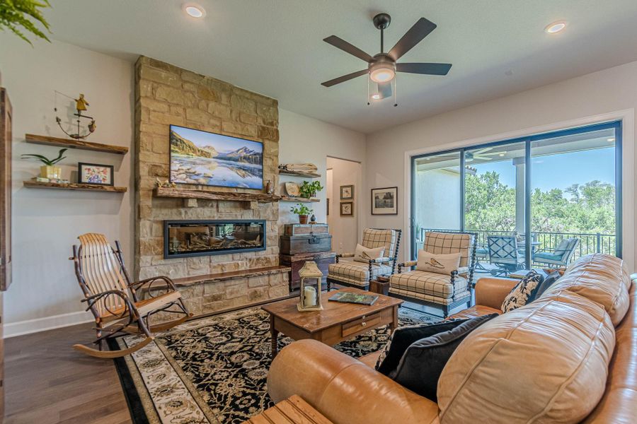 Living area with ceiling fan, wood finished floors, a stone fireplace, and recessed lighting