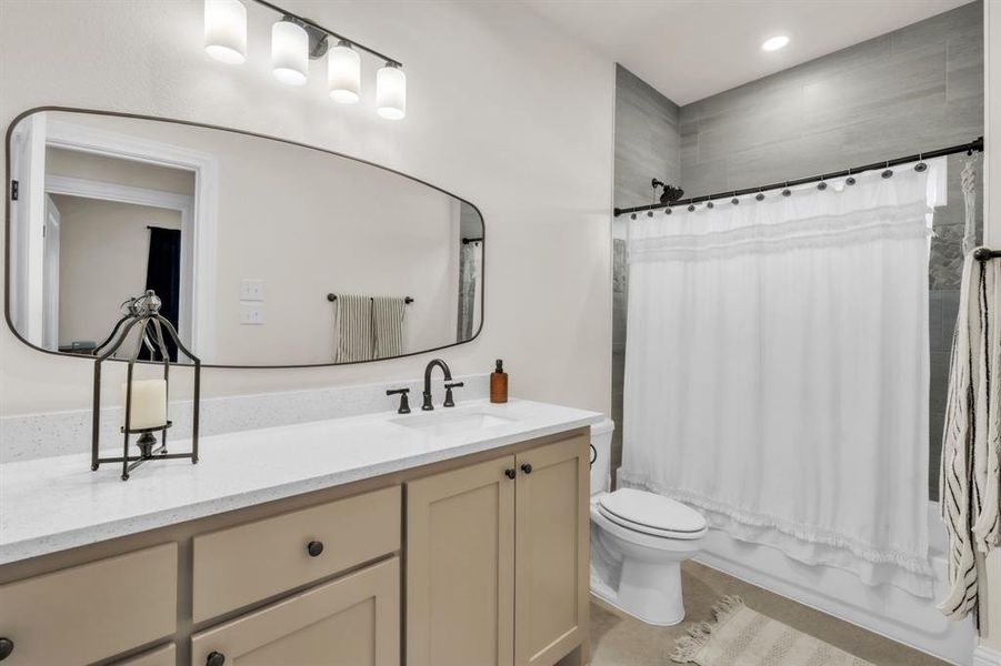 Full bathroom featuring shower / bath combo, vanity, and recessed lighting Full bathroom featuring shower / bath combo, vanity, and recessed lighting